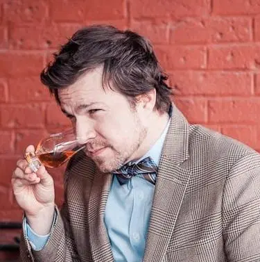 Picture of Tom Fischer sniffing a glass of bourbon